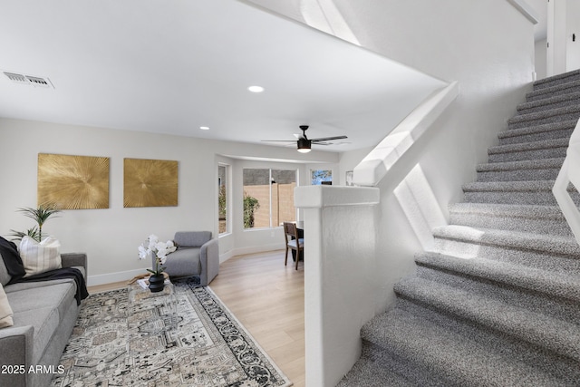 staircase featuring baseboards, visible vents, a ceiling fan, wood finished floors, and recessed lighting