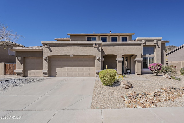 view of front of property with stucco siding, a garage, a tiled roof, and concrete driveway