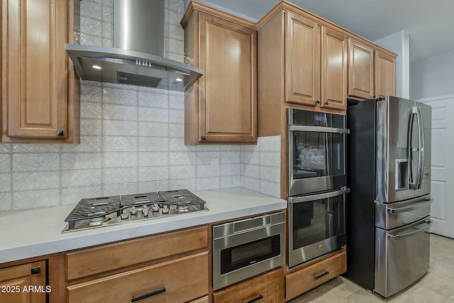 kitchen with light tile patterned flooring, light countertops, wall chimney exhaust hood, stainless steel appliances, and tasteful backsplash
