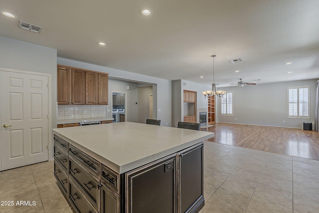kitchen with decorative backsplash, visible vents, and light tile patterned floors