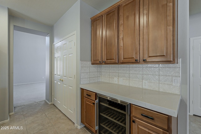 bar featuring backsplash, beverage cooler, light tile patterned floors, baseboards, and a dry bar