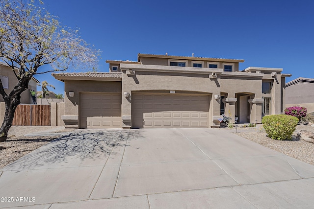 view of front of property with a tile roof, stucco siding, fence, driveway, and a garage