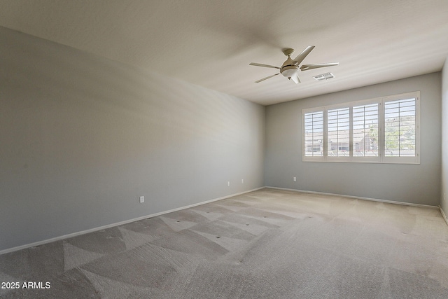 carpeted empty room featuring baseboards, visible vents, and ceiling fan