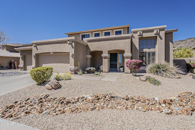 view of front of house with stucco siding, concrete driveway, and a garage