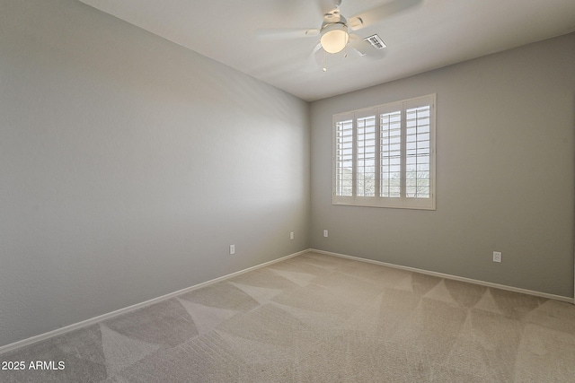 spare room featuring baseboards, visible vents, ceiling fan, and carpet