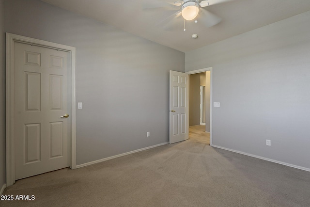 empty room with baseboards, ceiling fan, and light colored carpet