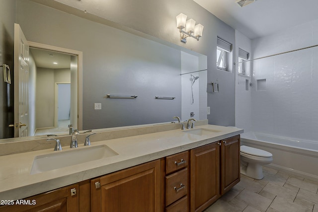 bathroom with toilet, a sink, double vanity, and shower / washtub combination