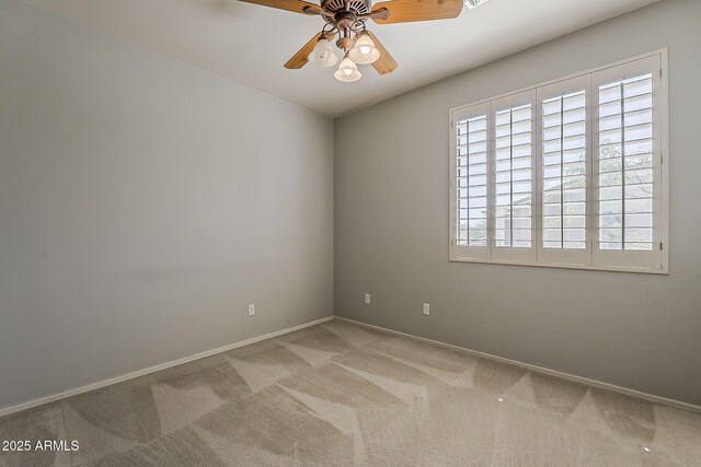 spare room with baseboards, ceiling fan, and carpet