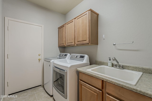 clothes washing area with washer and clothes dryer, cabinet space, a sink, and light tile patterned floors