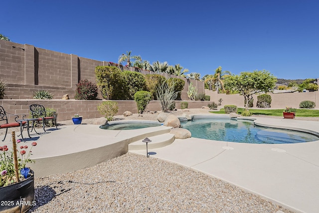 view of swimming pool featuring a patio, a fenced in pool, a fenced backyard, and an in ground hot tub