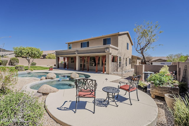 rear view of house featuring a fenced backyard, a fenced in pool, stucco siding, and a patio