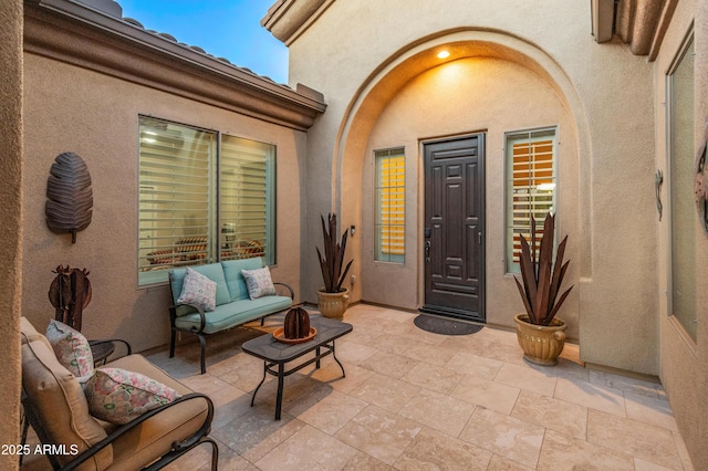 view of exterior entry with an outdoor hangout area and a patio