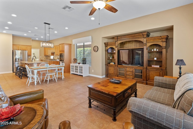 tiled living room featuring sink and ceiling fan