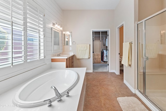 bathroom featuring tile patterned flooring, shower with separate bathtub, and vanity