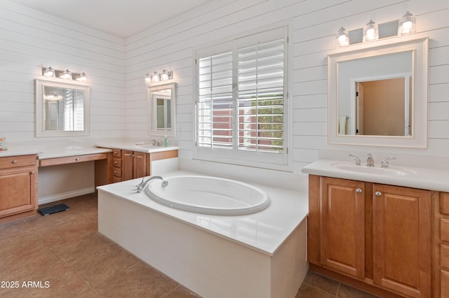 bathroom featuring a washtub, vanity, wooden walls, and tile patterned floors