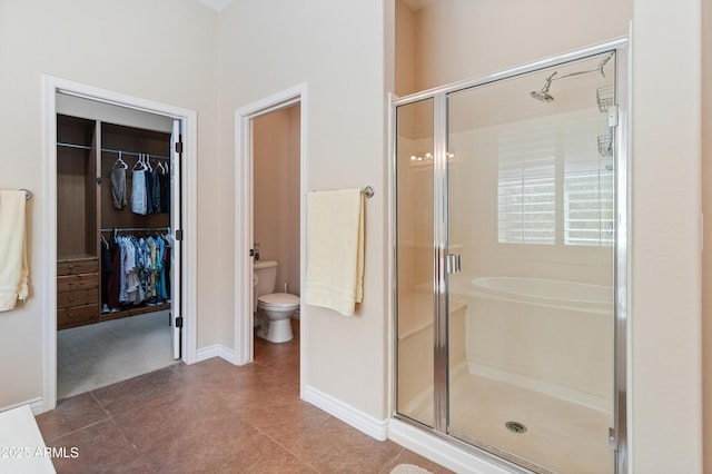 bathroom featuring tile patterned floors, toilet, and a shower with door