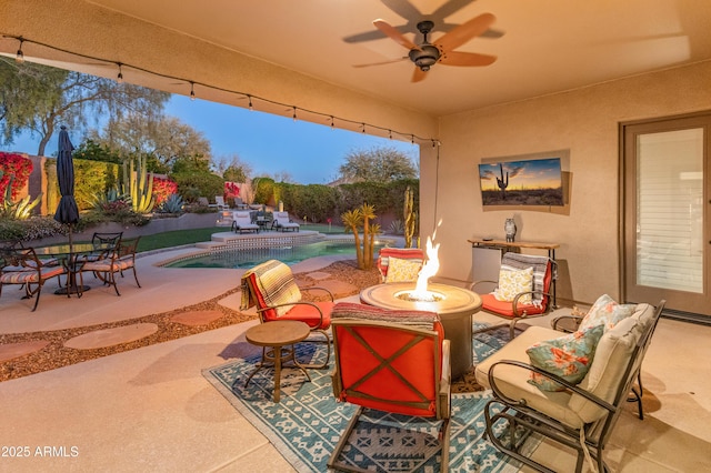 view of patio featuring ceiling fan and an outdoor fire pit