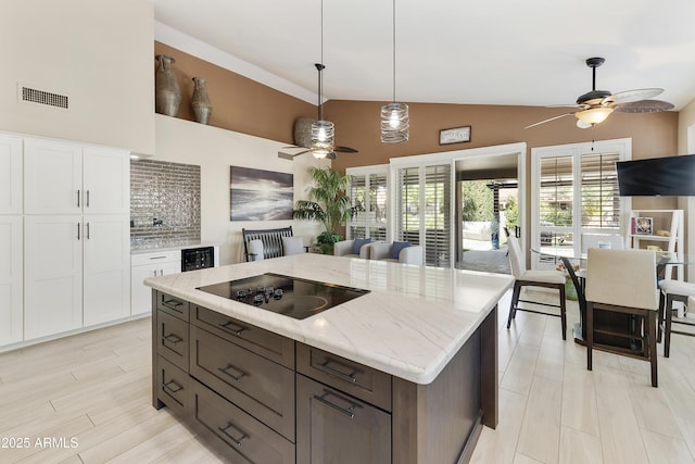 25042 S Hollygreen Dr, Sun Lakes, AZ 85248 - kitchen with visible vents, ceiling fan, black electric stovetop, white cabinets, and hanging light fixtures