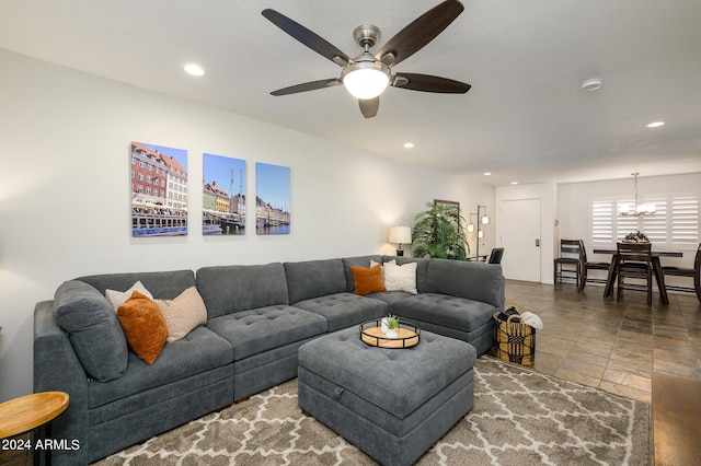 living room with ceiling fan with notable chandelier