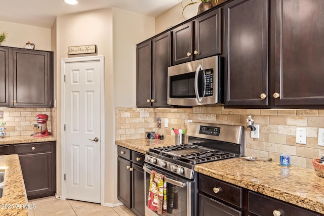 kitchen featuring appliances with stainless steel finishes, dark brown cabinetry, and tasteful backsplash