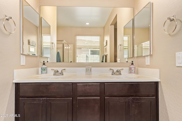 full bathroom with a shower stall and double vanity
