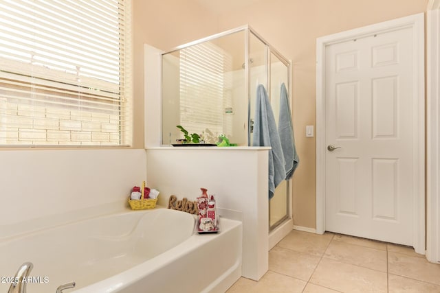 full bathroom featuring tile patterned flooring, a garden tub, and a stall shower