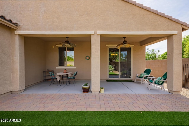 view of patio featuring ceiling fan and fence