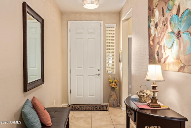 doorway featuring light tile patterned floors and baseboards