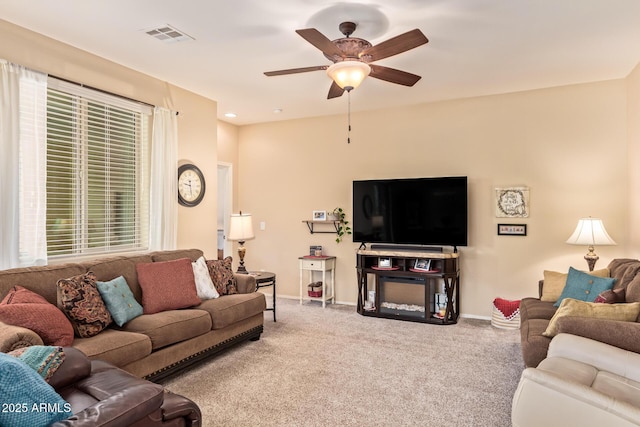 living room with carpet, ceiling fan, and baseboards