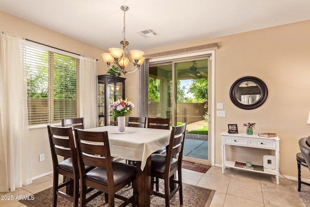 dining area with a chandelier, light tile patterned flooring, and healthy amount of natural light