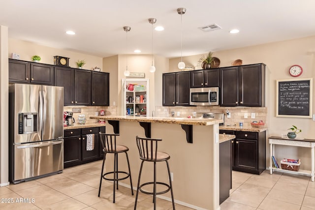 kitchen featuring appliances with stainless steel finishes, light tile patterned floors, a breakfast bar area, backsplash, and recessed lighting