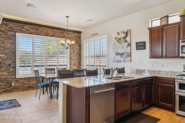 kitchen with appliances with stainless steel finishes, a chandelier, visible vents, and a sink