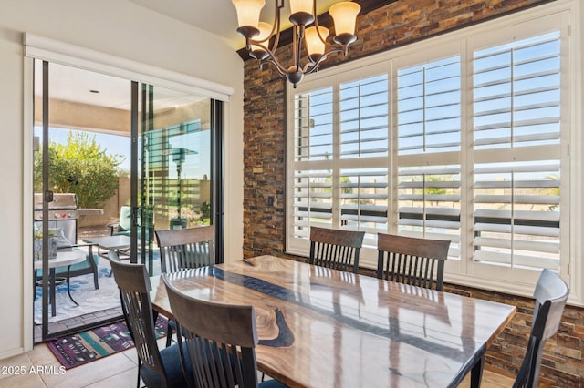 tiled dining space with a chandelier and a wealth of natural light