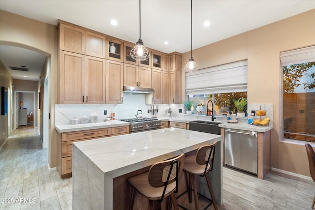 kitchen with visible vents, backsplash, a sink, dishwasher, and under cabinet range hood