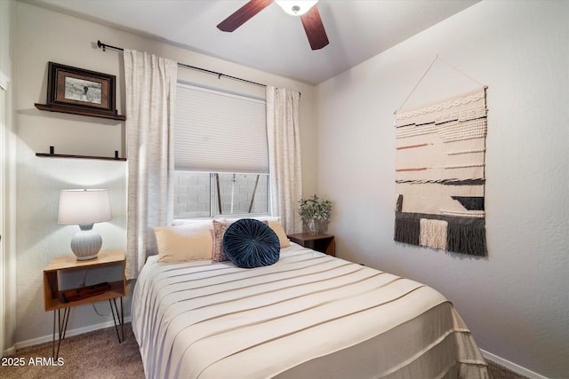 carpeted bedroom featuring baseboards and a ceiling fan