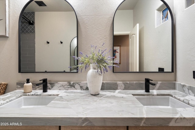 bathroom featuring a textured wall and vanity