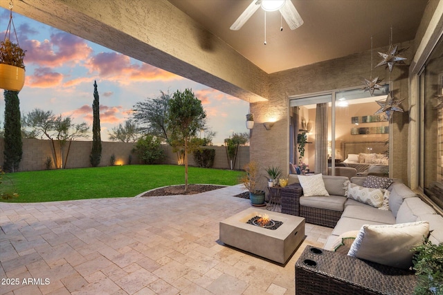 view of patio / terrace with ceiling fan, a fenced backyard, and an outdoor living space with a fire pit