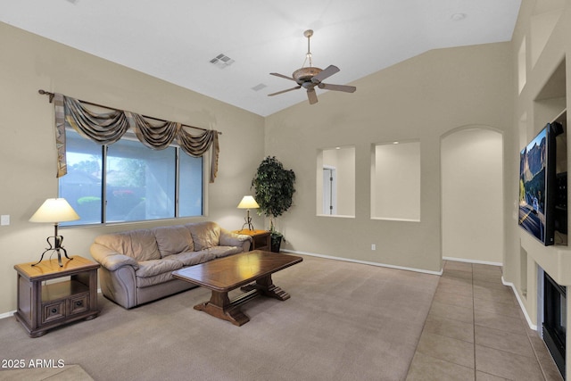 living room with lofted ceiling, light tile patterned floors, and ceiling fan