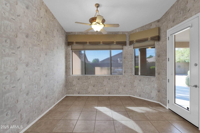 tiled spare room featuring ceiling fan