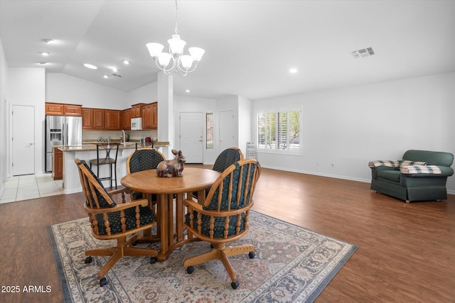 4976 S Sugarberry Ln, Gilbert, AZ 85298 - dining room with a chandelier, light wood finished floors, vaulted ceiling, recessed lighting, and baseboards