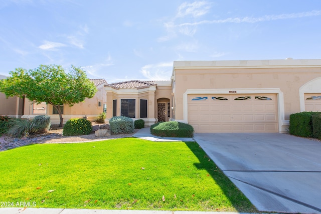 view of front of property featuring a garage and a front lawn