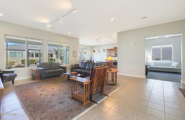 tiled living room with a wealth of natural light and ceiling fan