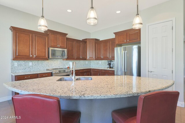 kitchen featuring pendant lighting, a center island with sink, plenty of natural light, and sink