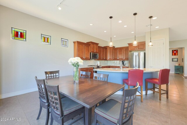 dining space with light tile patterned floors and sink