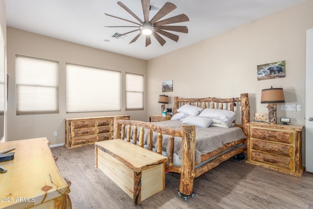 bedroom with multiple windows, wood-type flooring, and ceiling fan