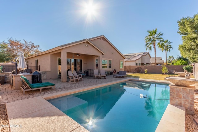 view of swimming pool with ceiling fan and a patio