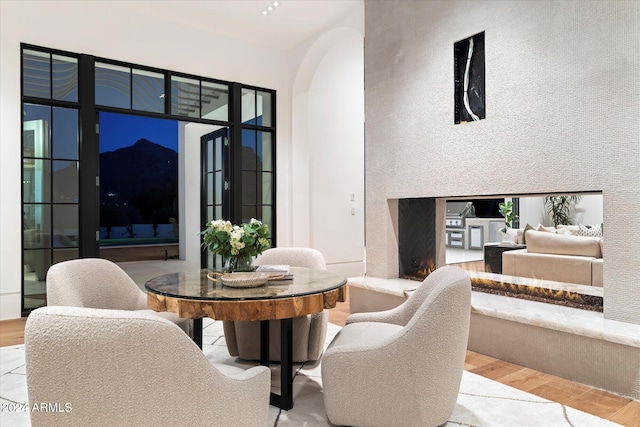 dining room with arched walkways and wood finished floors