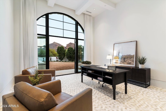 office space with beam ceiling, a mountain view, and a towering ceiling