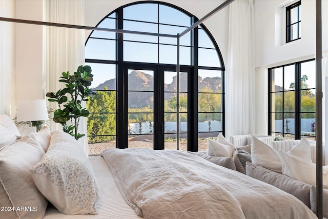 bedroom with multiple windows and a water and mountain view