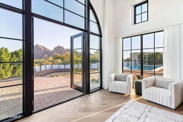 doorway featuring parquet flooring, a mountain view, a towering ceiling, and plenty of natural light